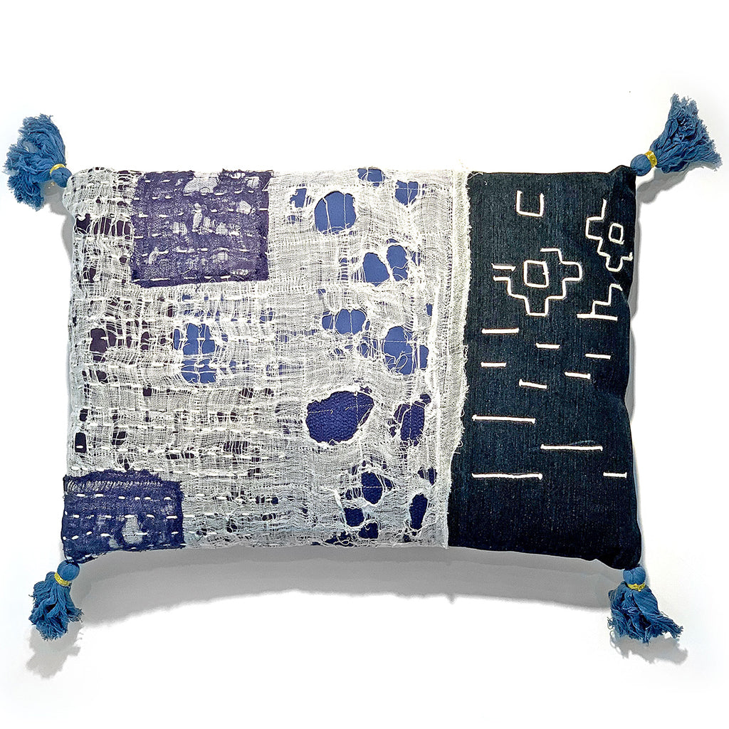 indigo and white decorative throw pillow with tassled blue corners