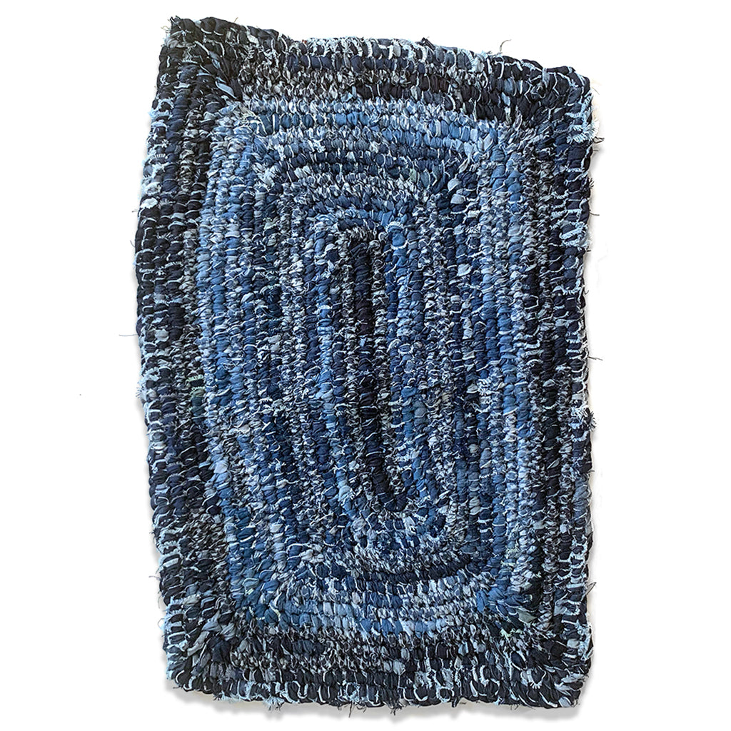 Hand Woven Upcycled Denim "Amish Knot" Rug. Rectangular shaped with different rows of varied coloured indigo.  